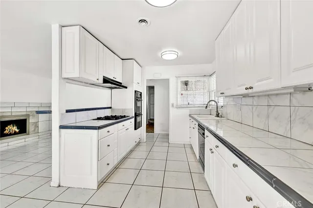 a kitchen with granite countertop a sink and a stove top oven