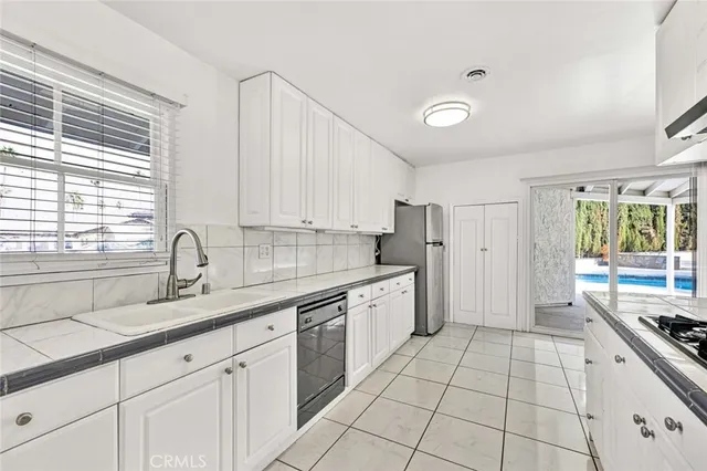 a kitchen with stainless steel appliances granite countertop a sink and a stove