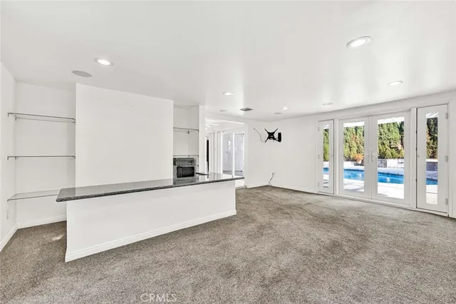 a large white kitchen with stainless steel appliances a large counter top and a refrigerator