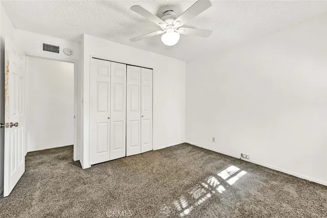 an empty room with a ceiling fan and a window