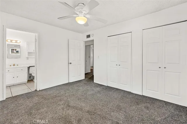 an empty room with closet and mirror
