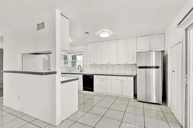 a kitchen with white cabinets and white appliances