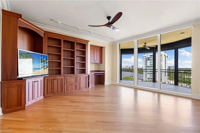 a view of empty room with wooden floor and floor to ceiling window