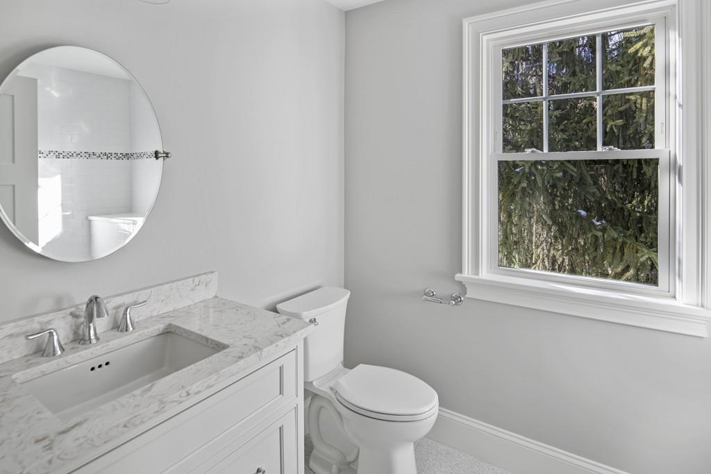114 Bow Street Lexington, MA 02420 - Photo 25 of 34 a bathroom with a toilet sink vanity and mirror
