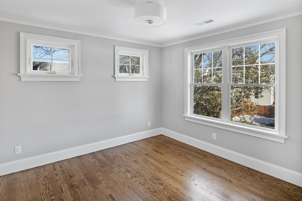 114 Bow Street Lexington, MA 02420 - Photo 27 of 34 a view of an empty room with wooden floor and a window