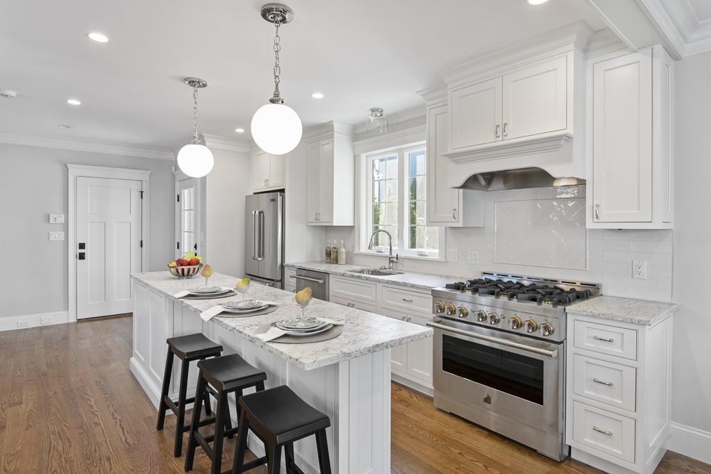 114 Bow Street Lexington, MA 02420 - Photo 4 of 34 a kitchen with a stove a table and chairs in it