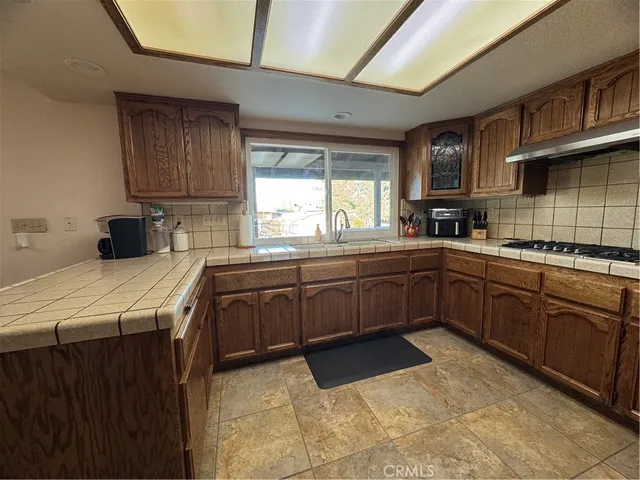 a kitchen with a sink a stove cabinets and a window