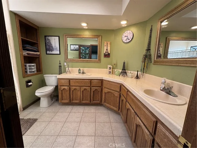 a bathroom with a double vanity sink mirror and toilet