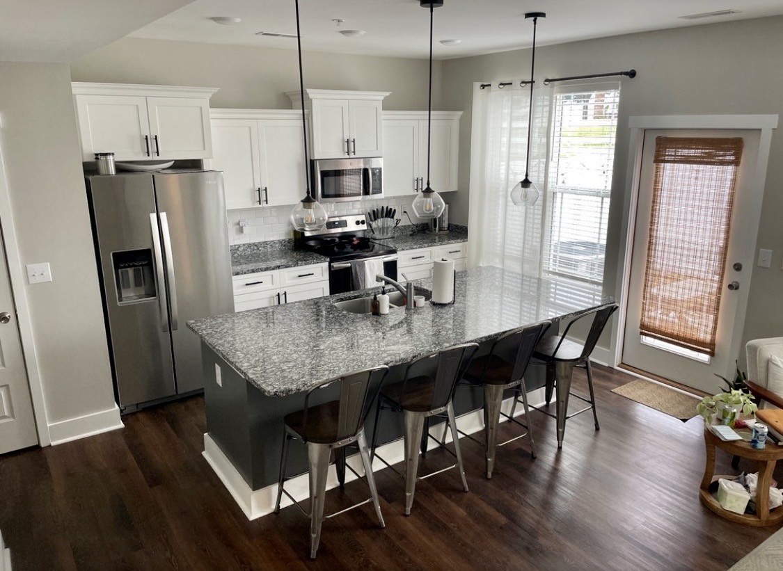 6052 Hillside Lane Spring Hill, TN 37174 - Photo 4 of 23 a kitchen with stainless steel appliances granite countertop a refrigerator a stove a sink a dining table and chairs with wooden floor