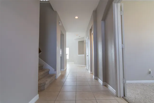 a view of a hallway with closet and a bathroom