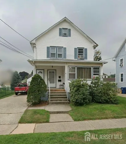 a front view of a house with a yard and potted plants