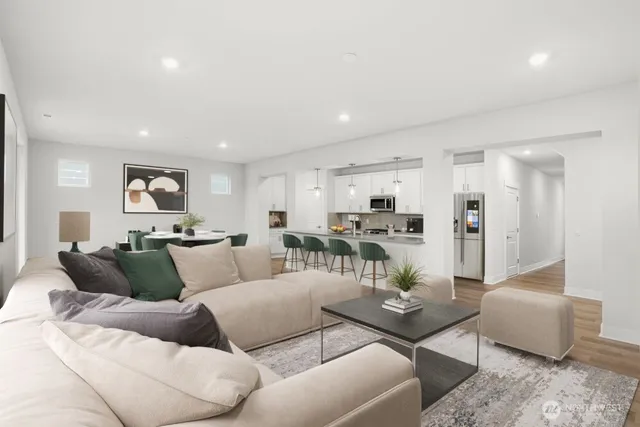 a living room with furniture and a view of kitchen