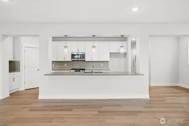 a large white kitchen with wooden floors