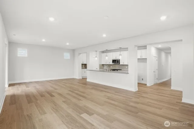 a view of a kitchen with a sink and dishwasher a refrigerator with wooden floor