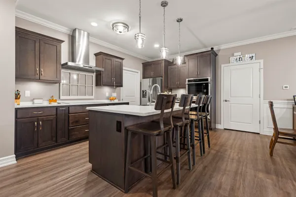 a kitchen with stainless steel appliances granite countertop wooden floors a stove and a refrigerator