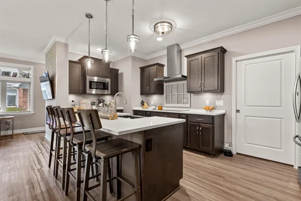 a kitchen with stainless steel appliances kitchen island granite countertop a sink a stove a dining table and chairs