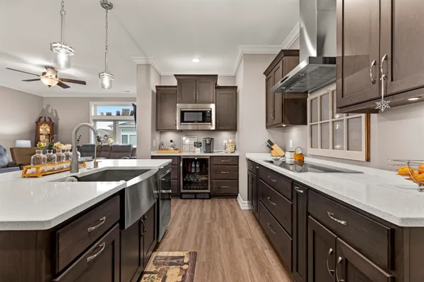 a kitchen with stainless steel appliances granite countertop a sink a stove and a wooden floors