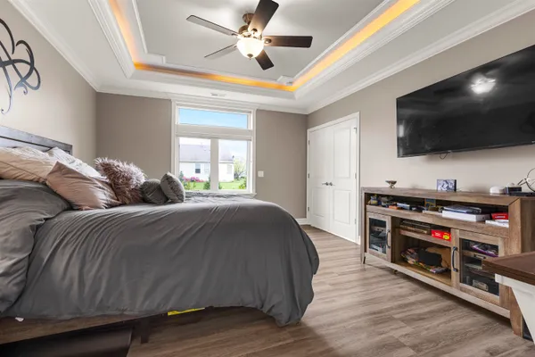 a spacious bedroom with a bed and a flat screen tv