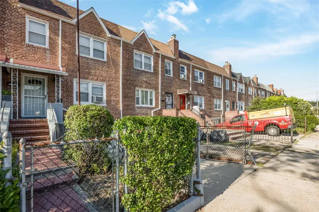 a view of a building with garden and parking area