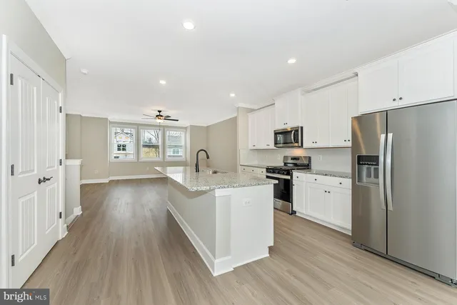a kitchen with white cabinets and stainless steel appliances