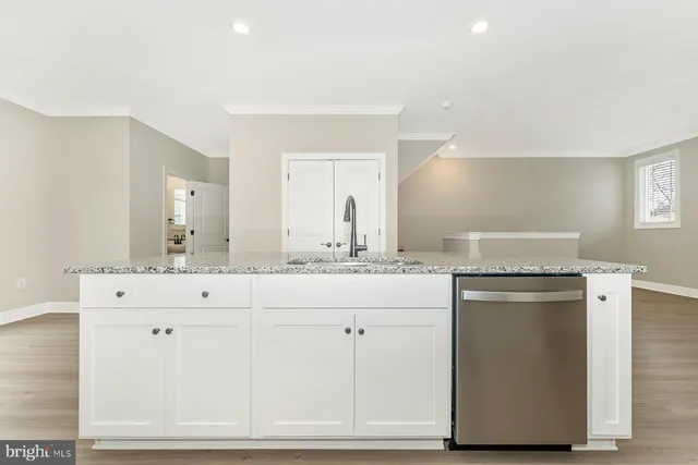 a kitchen with granite countertop white cabinets and a stainless steel appliances