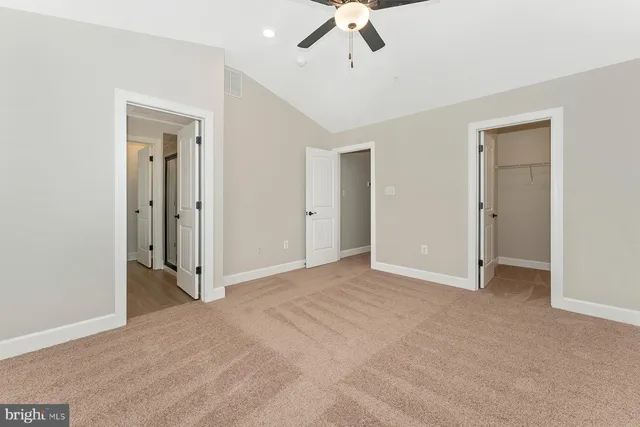 an empty room with fan and entrance