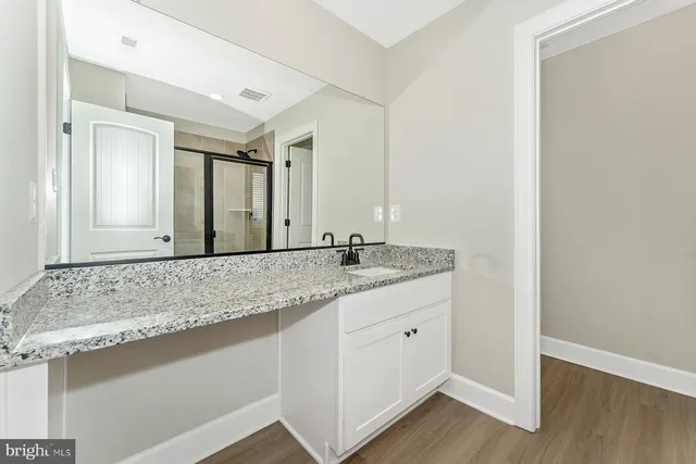 a bathroom with a granite countertop sink and a mirror