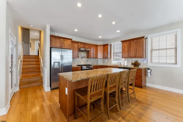 a kitchen with granite countertop stainless steel appliances a sink stove top oven and cabinets