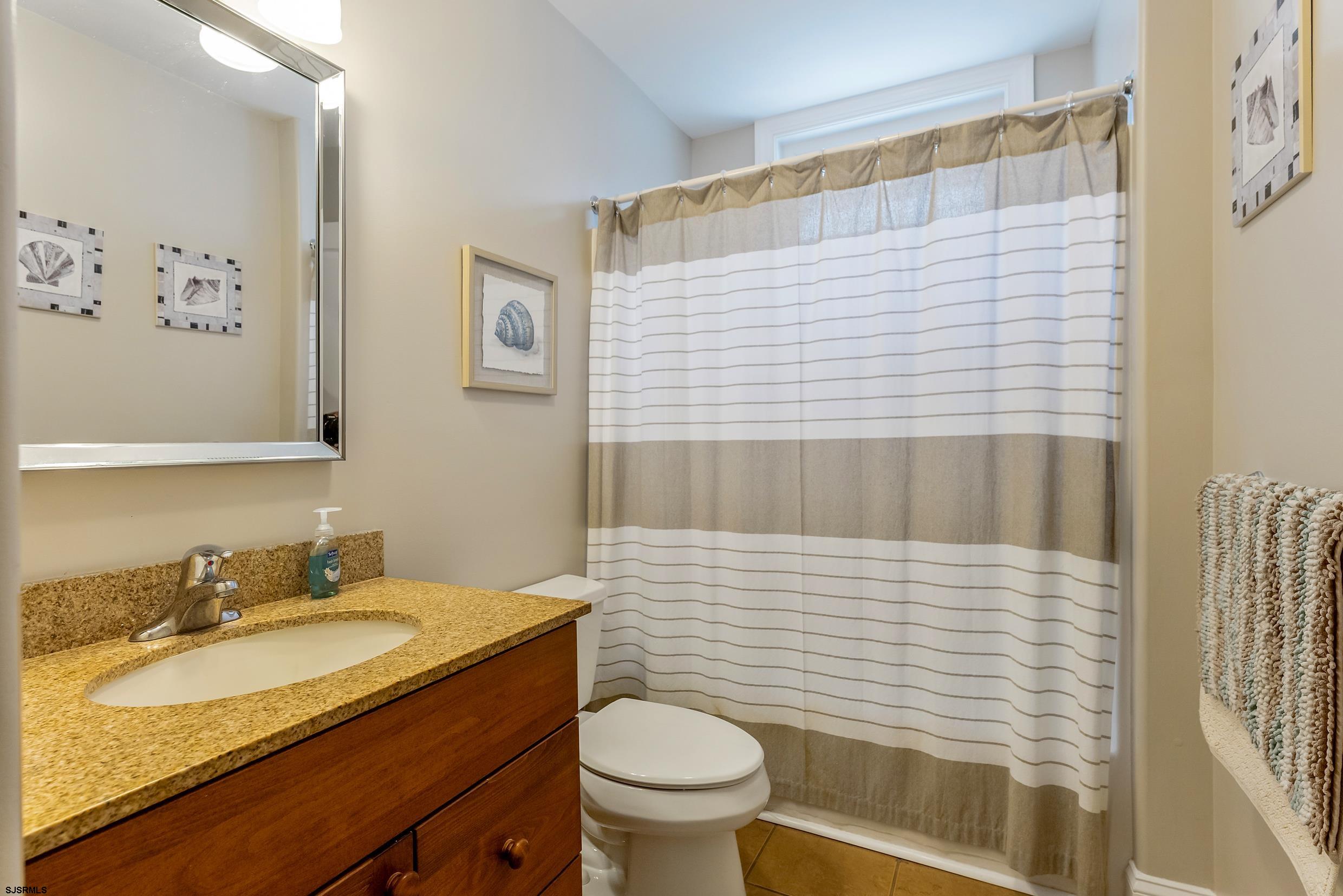 909 East 4th Street Ocean City, NJ 08226 - Photo 51 of 83 a bathroom with a granite countertop toilet sink and mirror