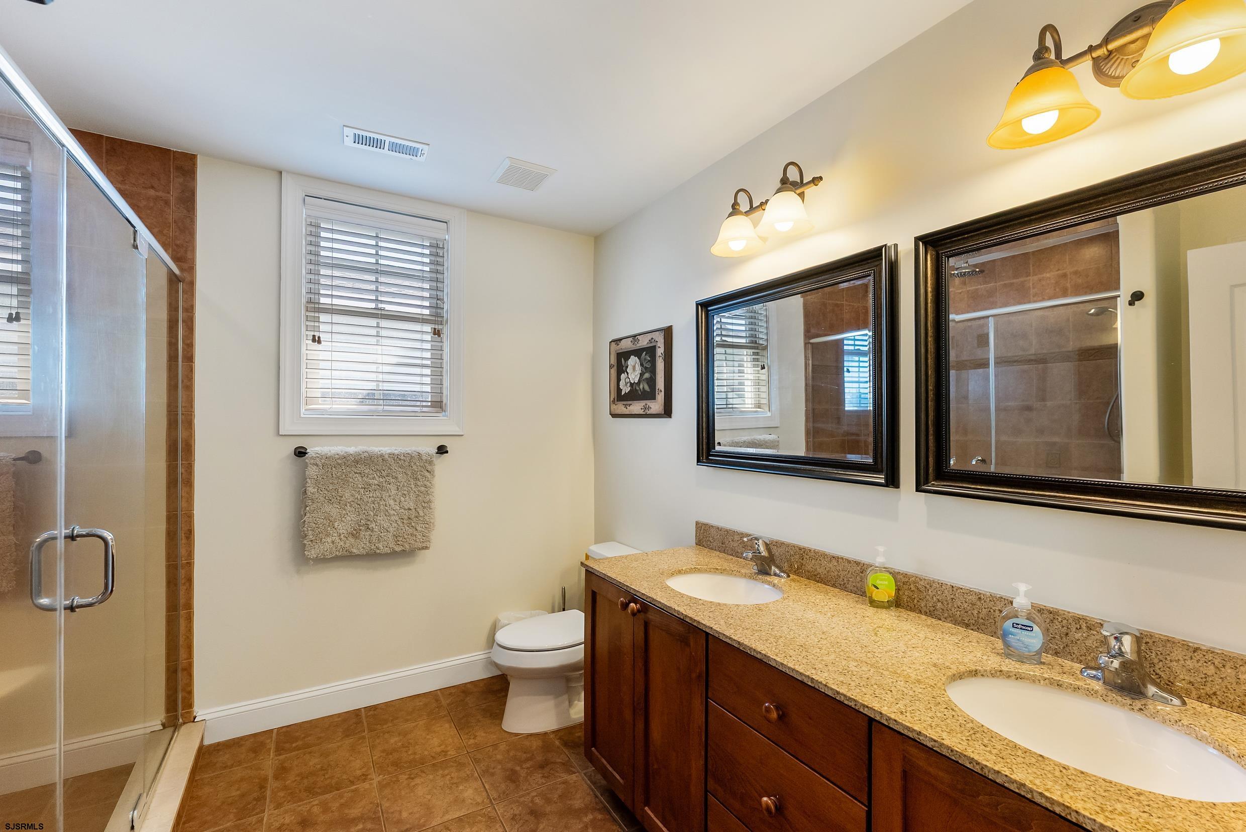 909 East 4th Street Ocean City, NJ 08226 - Photo 64 of 83 a spacious bathroom with a granite countertop sink toilet and a mirror