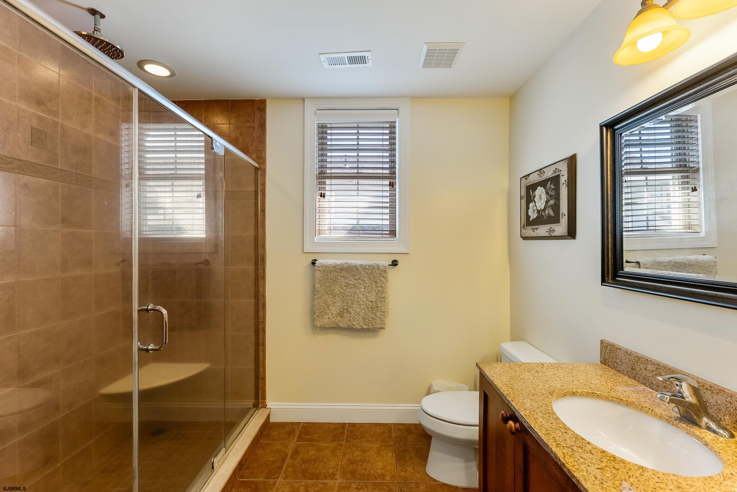 909 East 4th Street Ocean City, NJ 08226 - Photo 65 of 83 a bathroom with a granite countertop sink toilet and shower