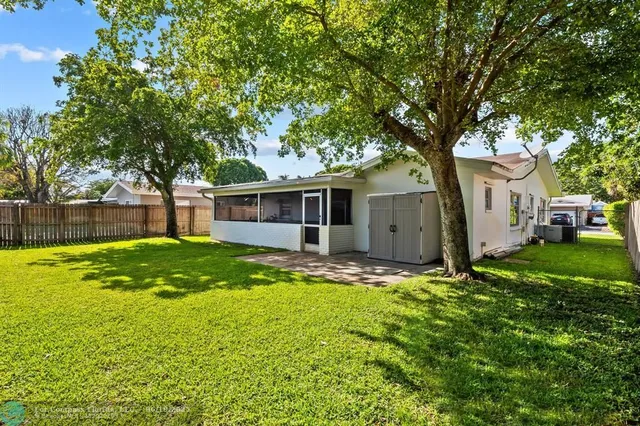 a view of a house with a big yard and large tree