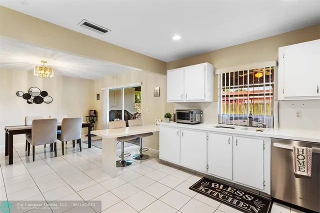 a white kitchen with sink and cabinets