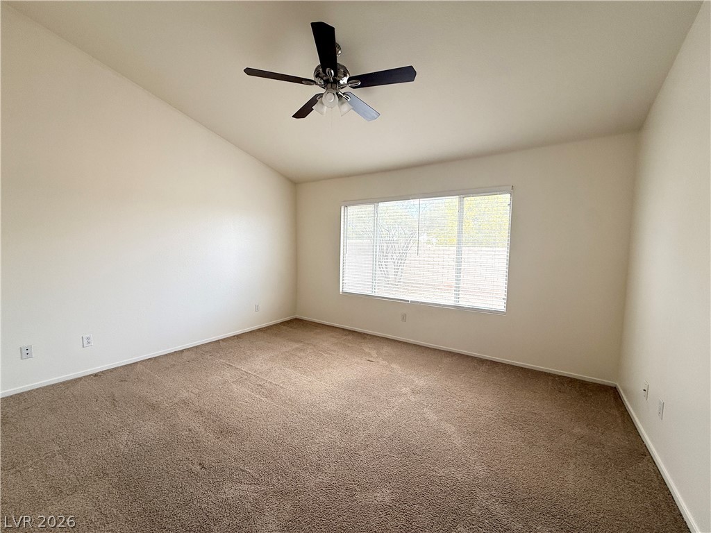 8870 Haviland Road Las Vegas, NV 89123 - Photo 9 of 24 A well-lit bedroom features vaulted ceilings and plush carpeting, creating a tranquil atmosphere.