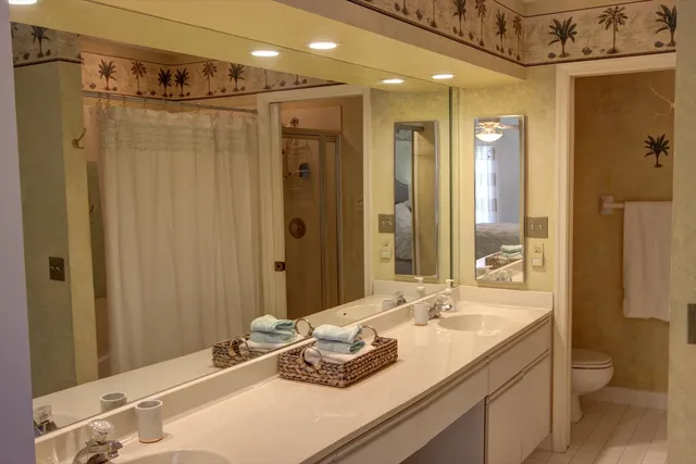 a bathroom with a granite countertop sink a toilet and shower