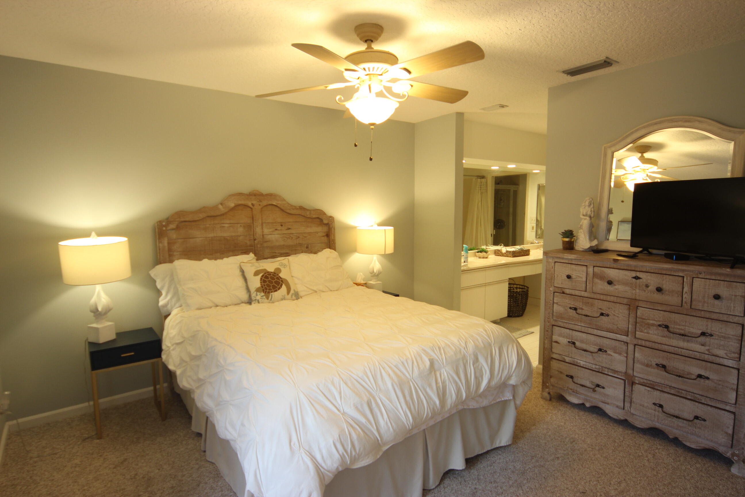 508 Sea Oats Drive, Unit B4 Juno Beach, FL 33408 - Photo 10 of 26 a bedroom with a bed and a chandelier