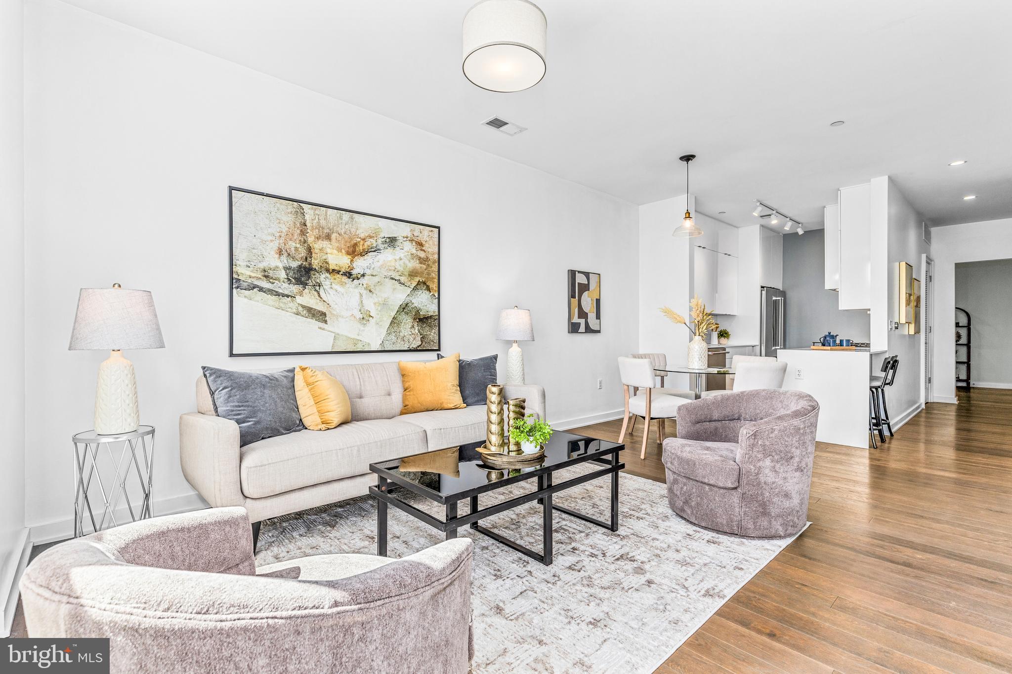 a living room with furniture and wooden floor