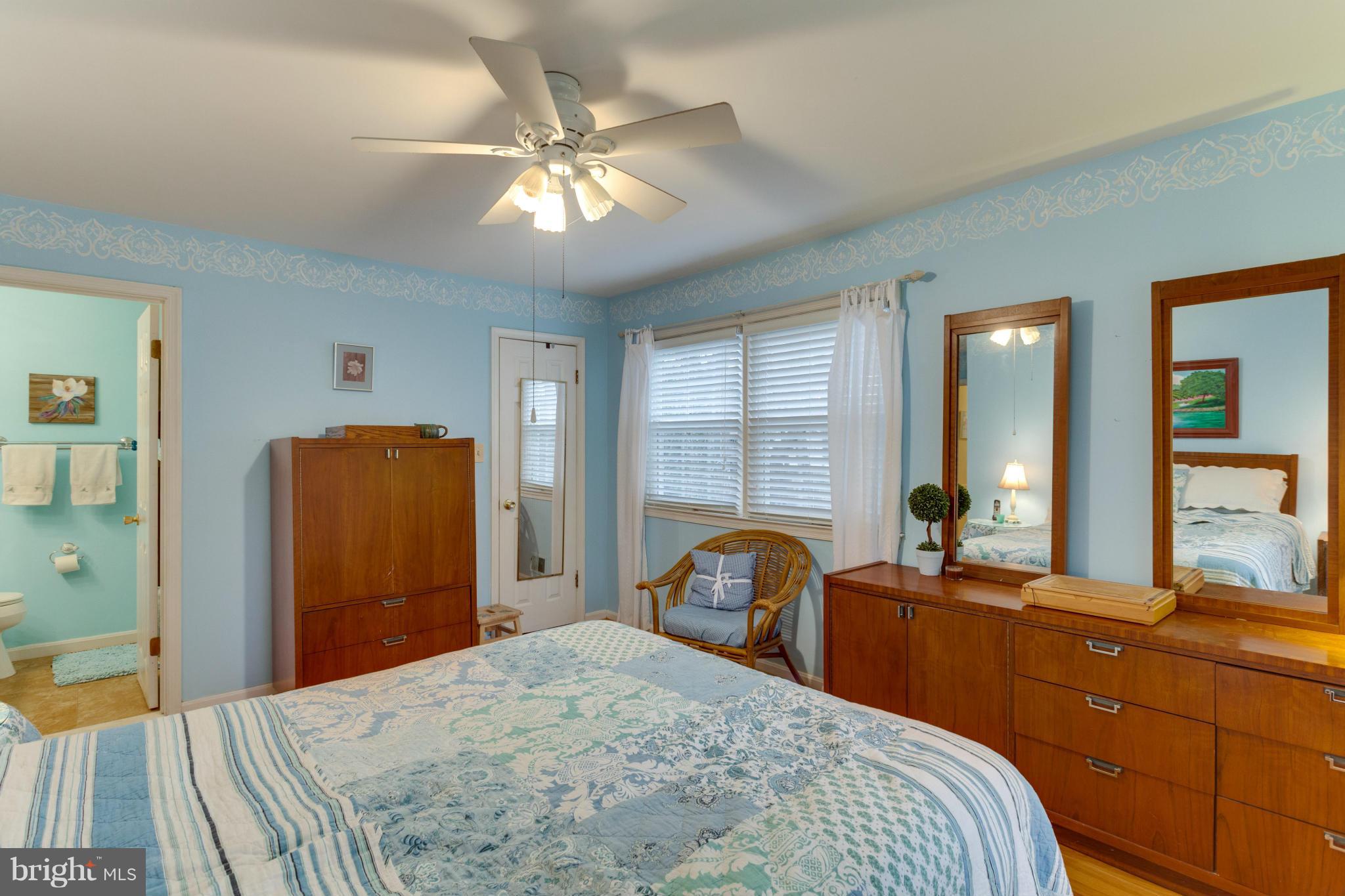 9810 Vale Road Vienna, VA 22181 - Photo 11 of 30 a bedroom with a bed and a large mirror with a chandelier