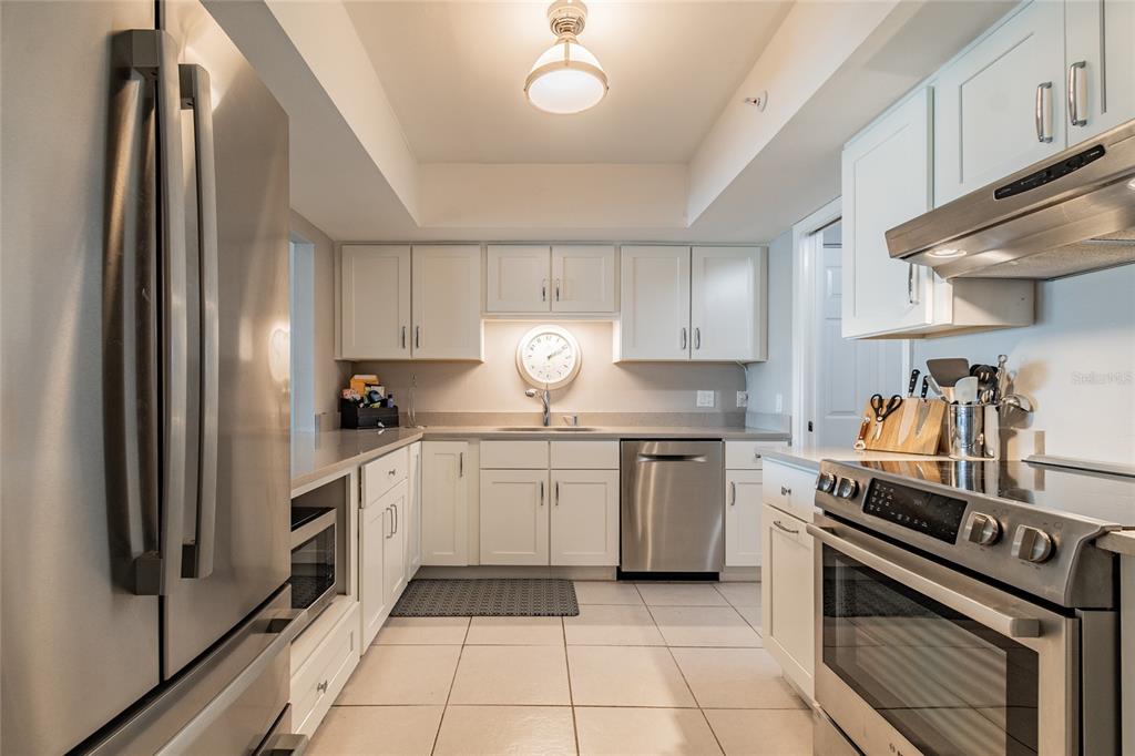 13650 Gulf Boulevard, Unit 402 Madeira Beach, FL 33708 - Photo 11 of 44 a kitchen with a stove sink and refrigerator