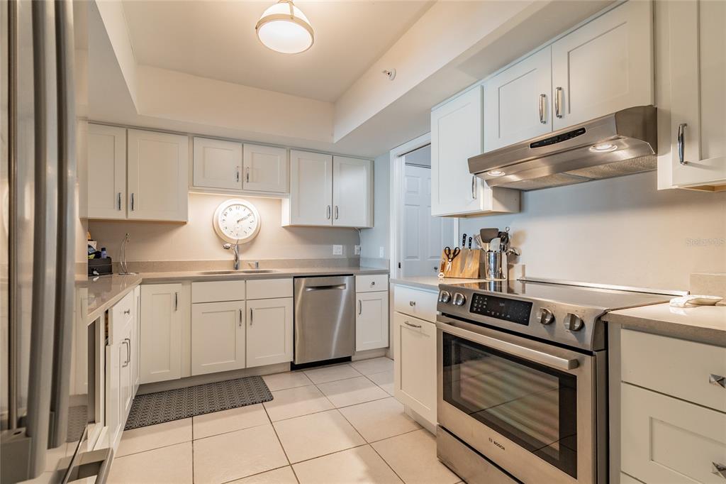 13650 Gulf Boulevard, Unit 402 Madeira Beach, FL 33708 - Photo 12 of 44 a kitchen with granite countertop cabinets and steel stainless steel appliances