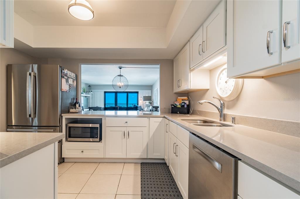 13650 Gulf Boulevard, Unit 402 Madeira Beach, FL 33708 - Photo 13 of 44 a kitchen with a sink stove and cabinets
