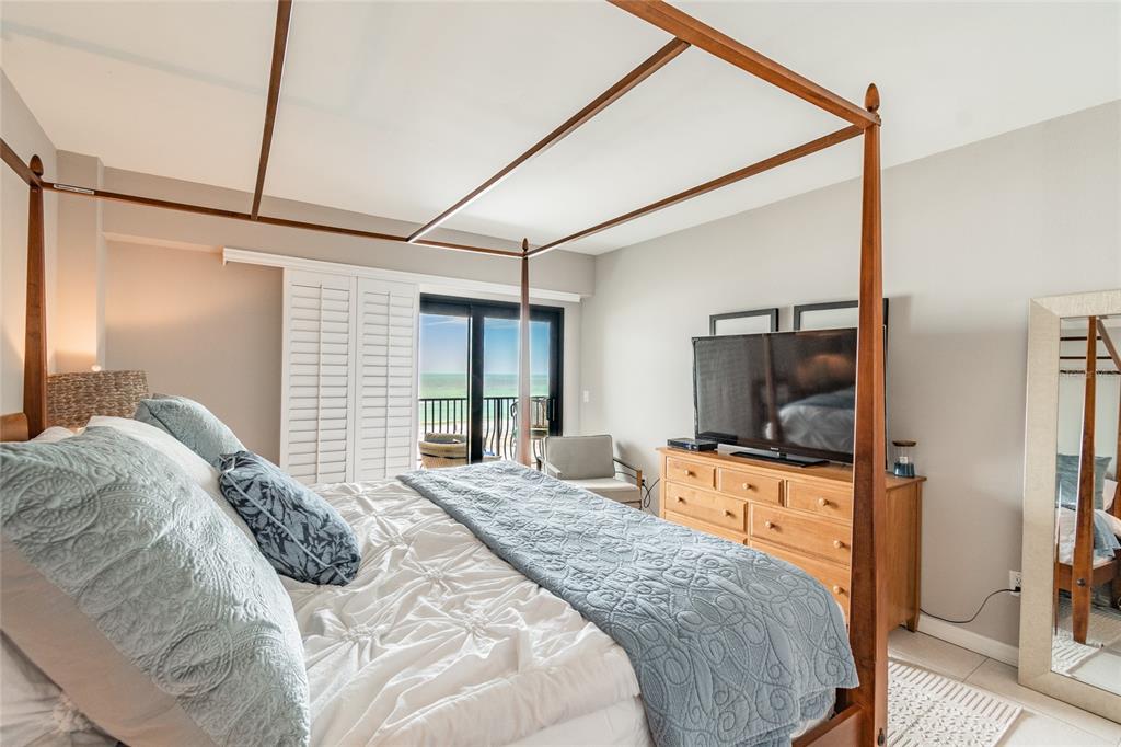 13650 Gulf Boulevard, Unit 402 Madeira Beach, FL 33708 - Photo 15 of 44 a bedroom with a bed and a flat screen tv