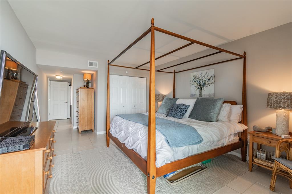13650 Gulf Boulevard, Unit 402 Madeira Beach, FL 33708 - Photo 16 of 44 a bedroom with a bed and a flat screen tv