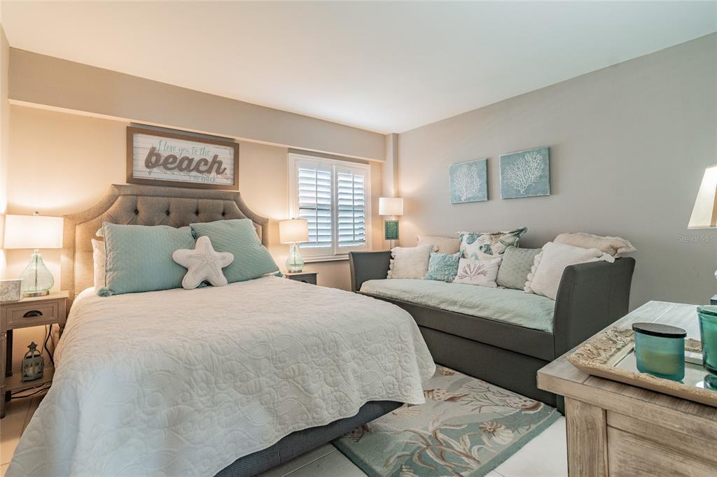 13650 Gulf Boulevard, Unit 402 Madeira Beach, FL 33708 - Photo 20 of 44 a bedroom with a bed and a couch