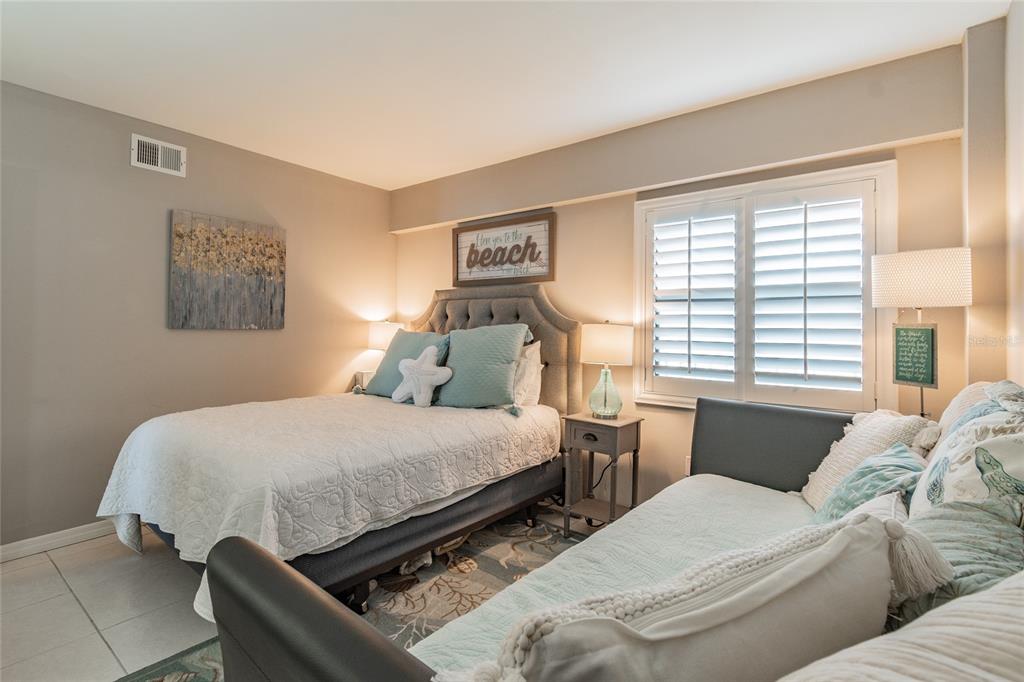 13650 Gulf Boulevard, Unit 402 Madeira Beach, FL 33708 - Photo 22 of 44 a bedroom with two beds and a window