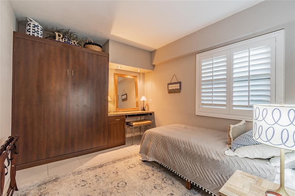 13650 Gulf Boulevard, Unit 402 Madeira Beach, FL 33708 - Photo 25 of 44 a bedroom with a bed and a window