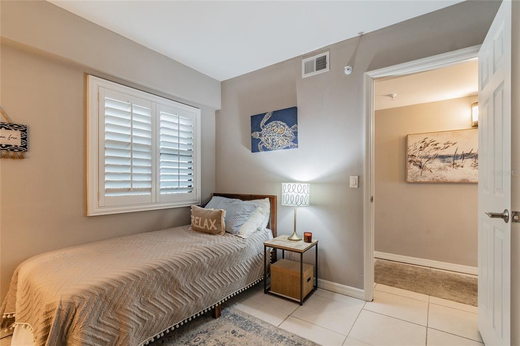 13650 Gulf Boulevard, Unit 402 Madeira Beach, FL 33708 - Photo 26 of 44 a bedroom with a bed and a window