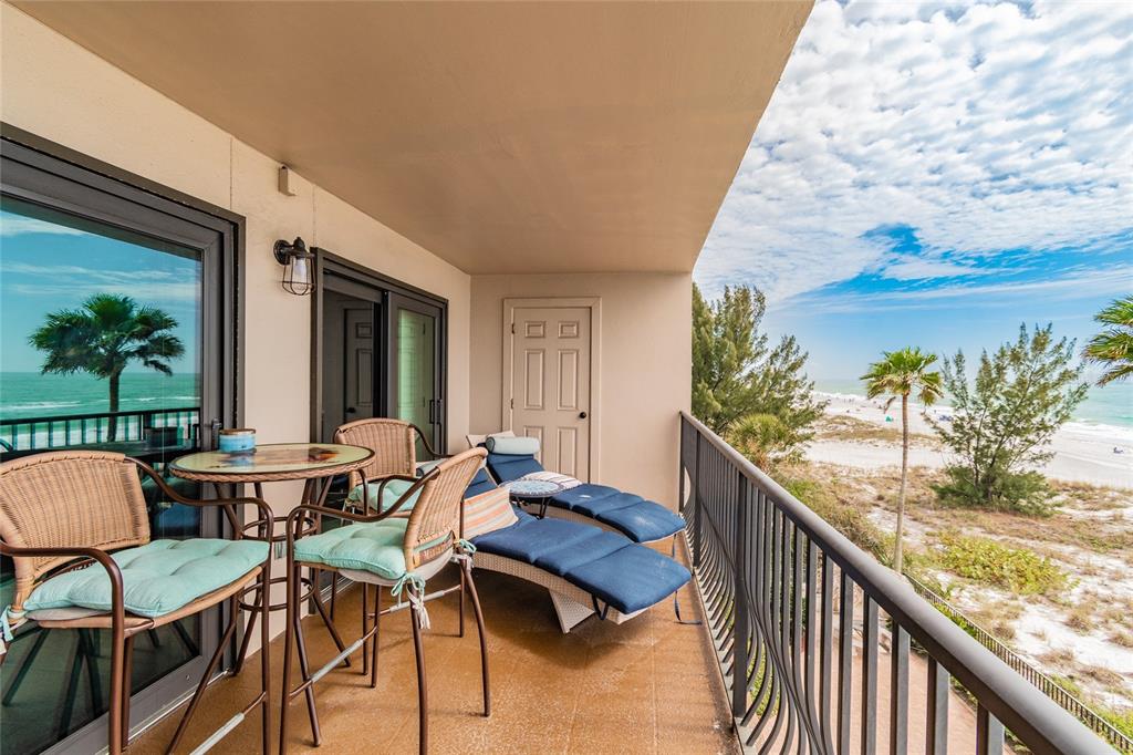 13650 Gulf Boulevard, Unit 402 Madeira Beach, FL 33708 - Photo 28 of 44 a view of balcony with chairs and wooden fence