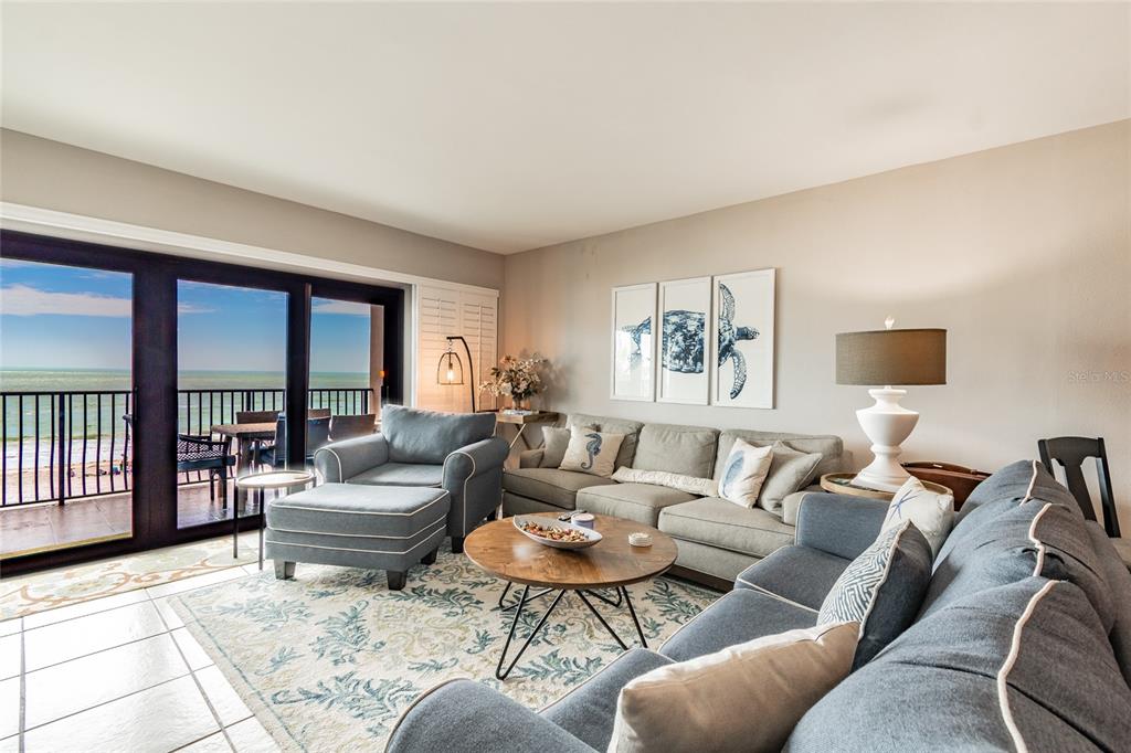 13650 Gulf Boulevard, Unit 402 Madeira Beach, FL 33708 - Photo 3 of 44 a living room with furniture and a large window