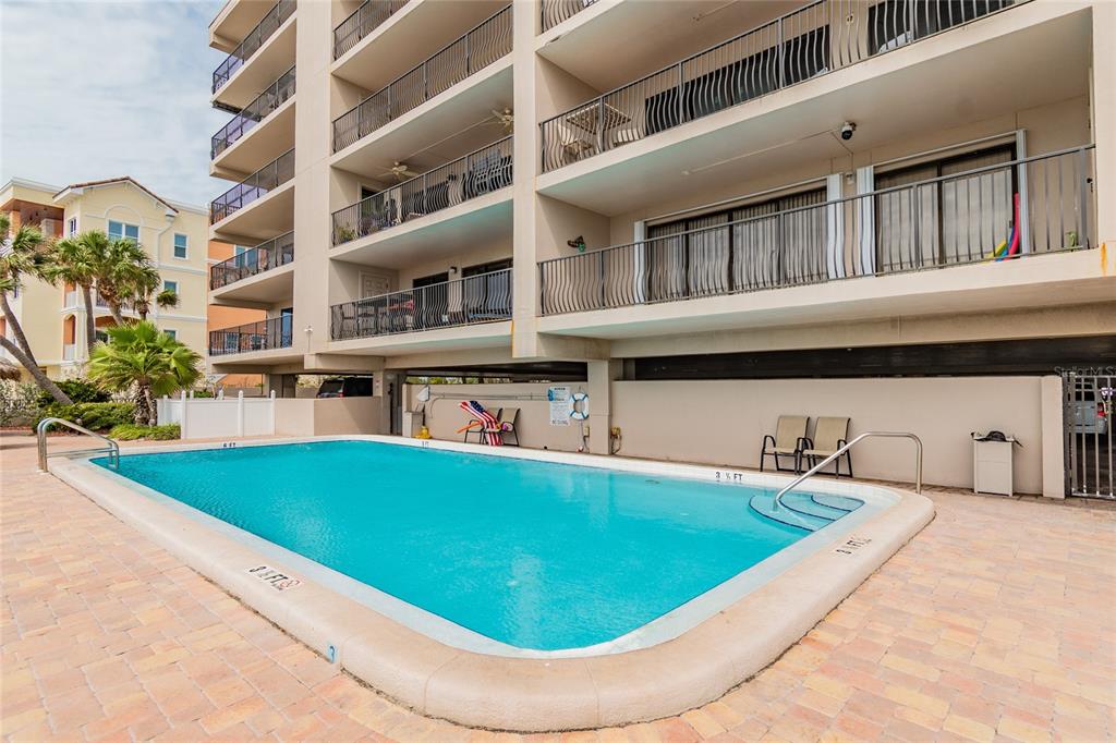 13650 Gulf Boulevard, Unit 402 Madeira Beach, FL 33708 - Photo 36 of 44 a view of a swimming pool with an outdoor seating